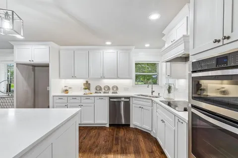 a kitchen with a sink a stove and cabinets