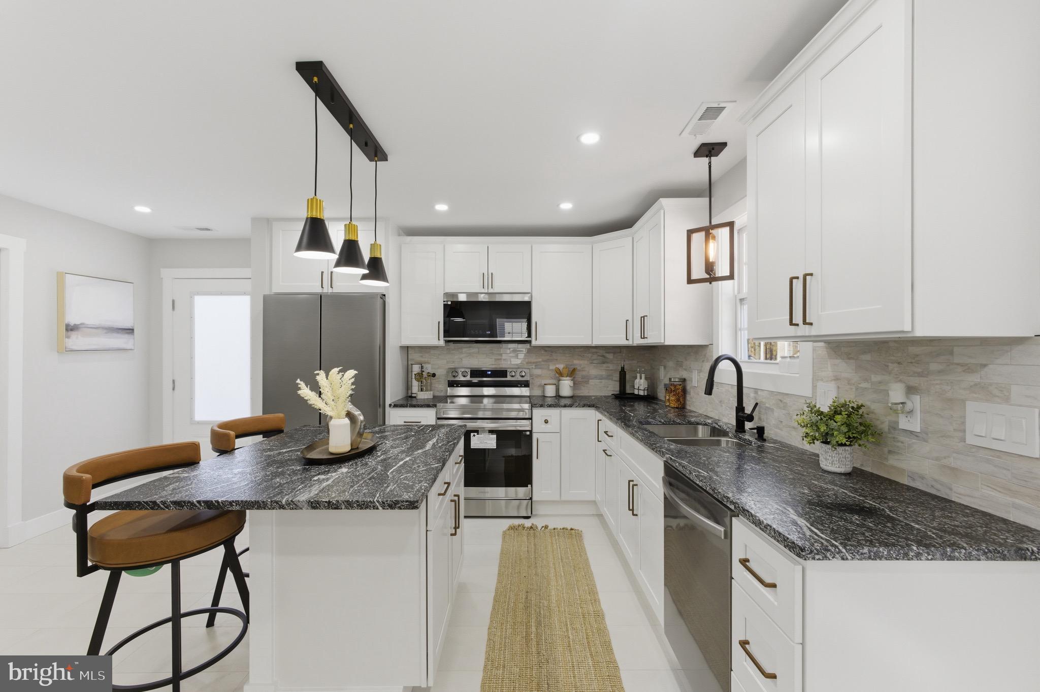 a kitchen with kitchen island granite countertop a sink a counter space appliances and cabinets