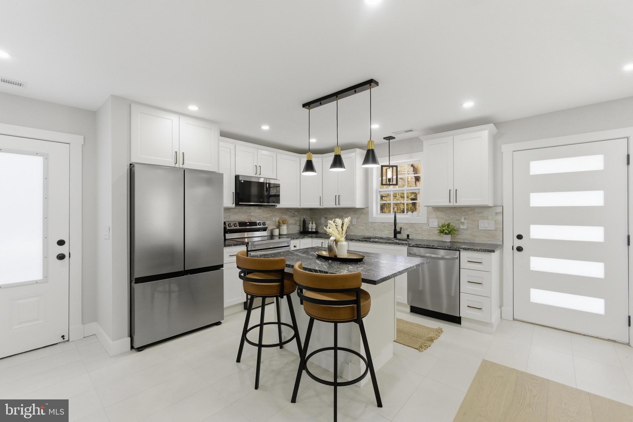 5218 Nick Road Shady Side, MD 20764 - Photo 3 of 24 a kitchen with stainless steel appliances granite countertop a refrigerator a stove a sink a dining table and chairs