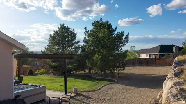 1797 Sunset Road Enoch, UT 84721 - Photo 59 of 80 Expansive exterior featuring a pergola-covered patio, manicured lawn, and natural rock landscaping