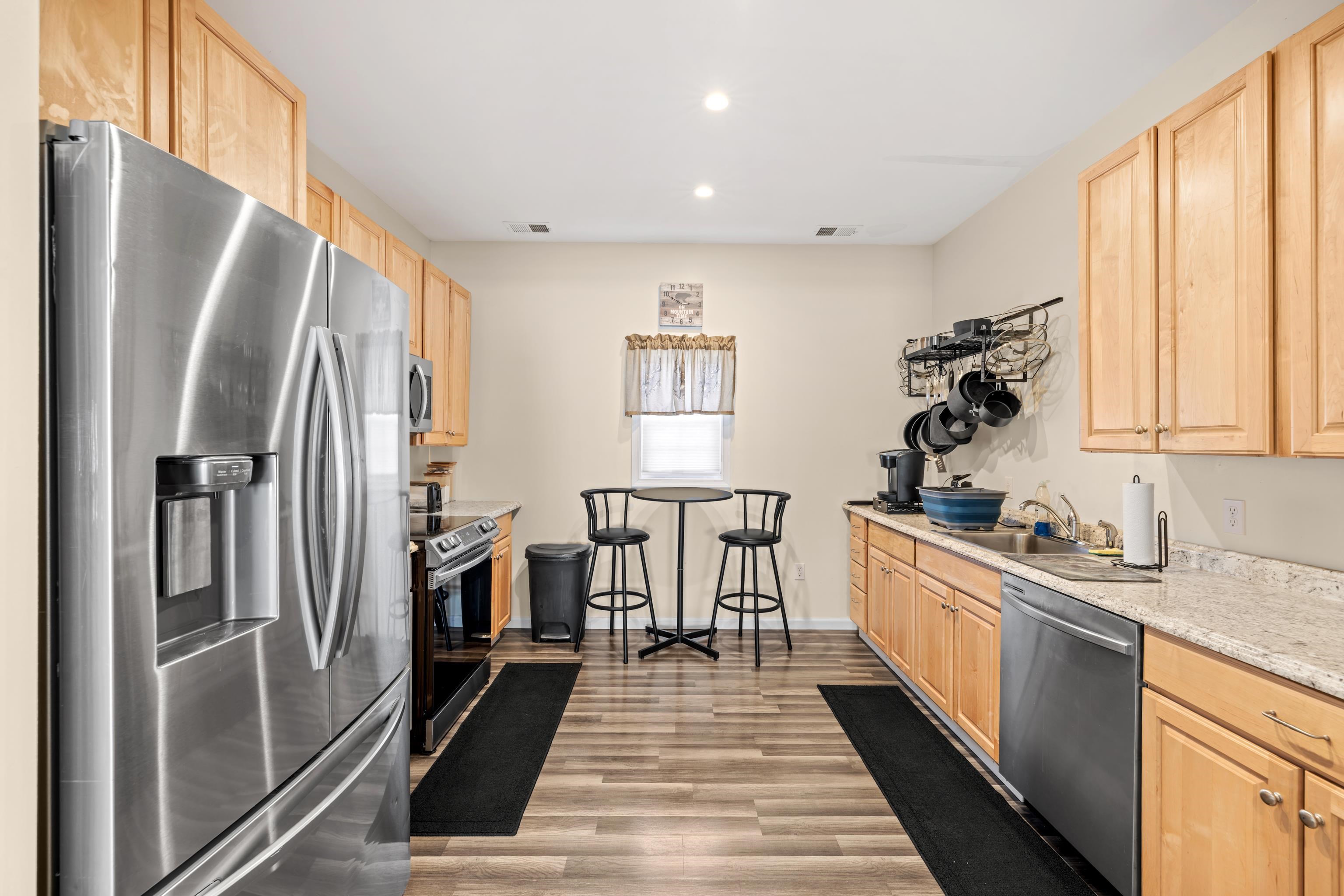 493 Railroad Avenue Goshen, VA 24439 - Photo 12 of 66 a kitchen with white cabinets and stainless steel appliances