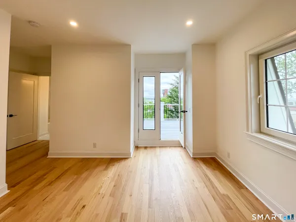an empty room with wooden floor and windows