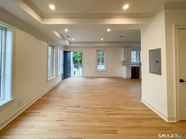 a view of an empty room with window and wooden floor