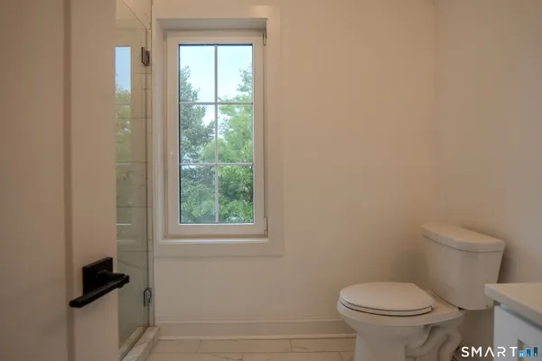 a bathroom with a toilet and a window