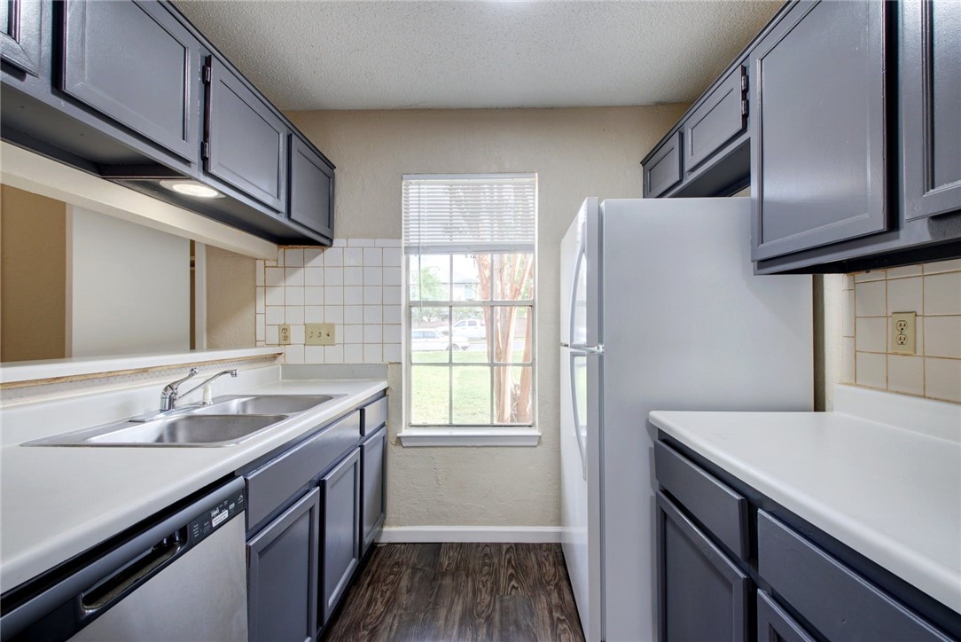 2003 Pipers Field Drive, Unit A Austin, TX 78758 - Photo 13 of 25 a kitchen with a sink cabinets stainless steel appliances and a window