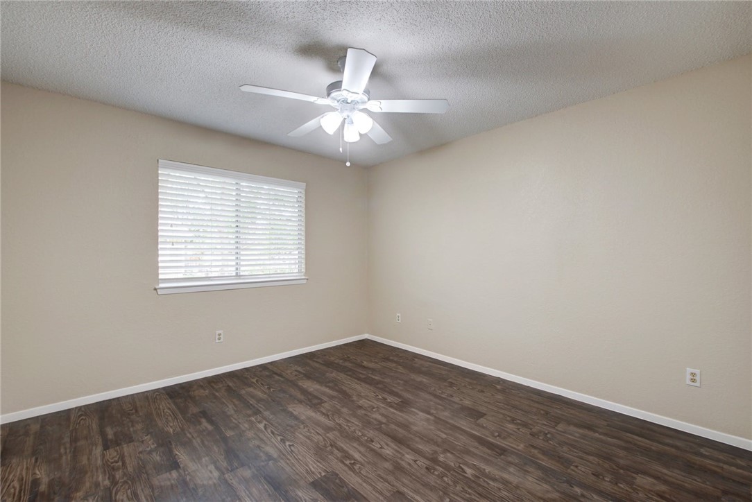 2003 Pipers Field Drive, Unit A Austin, TX 78758 - Photo 18 of 25 an empty room with wooden floor fan and windows