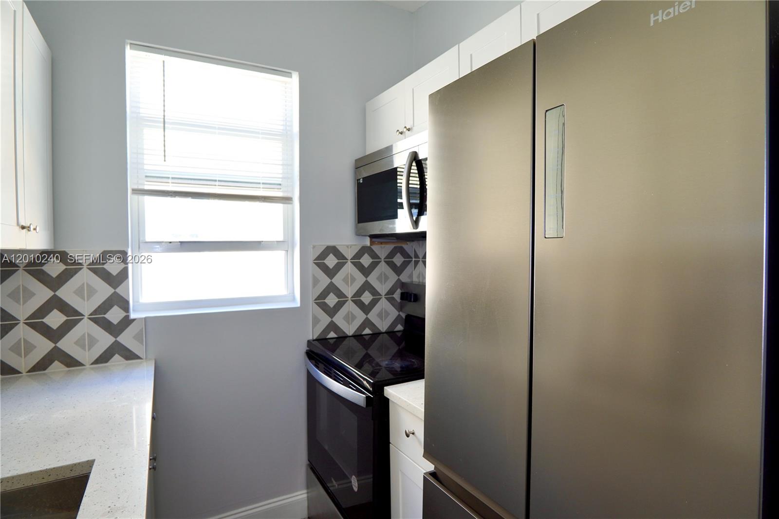 1142 Southwest 4th Street, Unit 17 Miami, FL 33130 - Photo 13 of 20 a kitchen with stainless steel appliances a refrigerator and a window