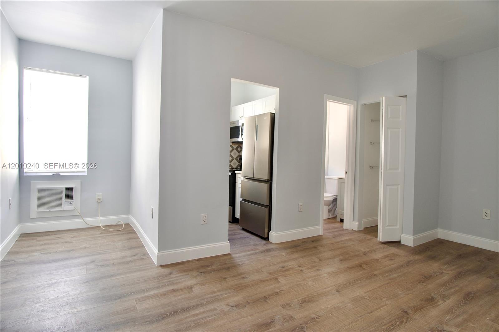 1142 Southwest 4th Street, Unit 17 Miami, FL 33130 - Photo 3 of 20 an empty room with wooden floor and windows