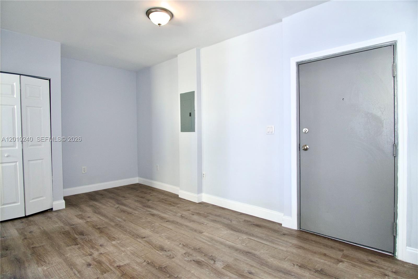 1142 Southwest 4th Street, Unit 17 Miami, FL 33130 - Photo 4 of 20 an empty room with wooden floor and windows