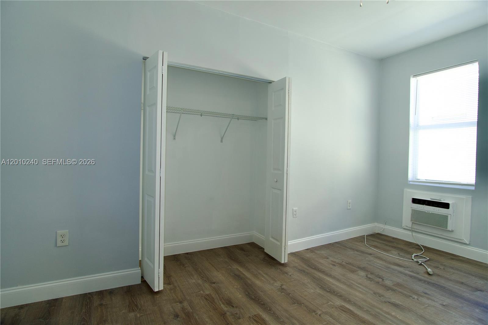 1142 Southwest 4th Street, Unit 17 Miami, FL 33130 - Photo 6 of 20 an empty room with wooden floor a ceiling fan and windows