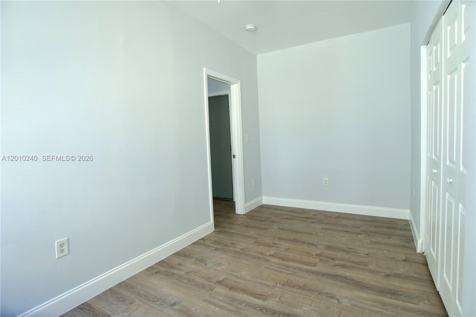 1142 Southwest 4th Street, Unit 17 Miami, FL 33130 - Photo 8 of 20 a view of an empty room with wooden floor