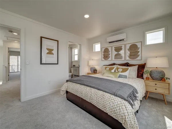 a spacious bedroom with a bed and painting on the wall