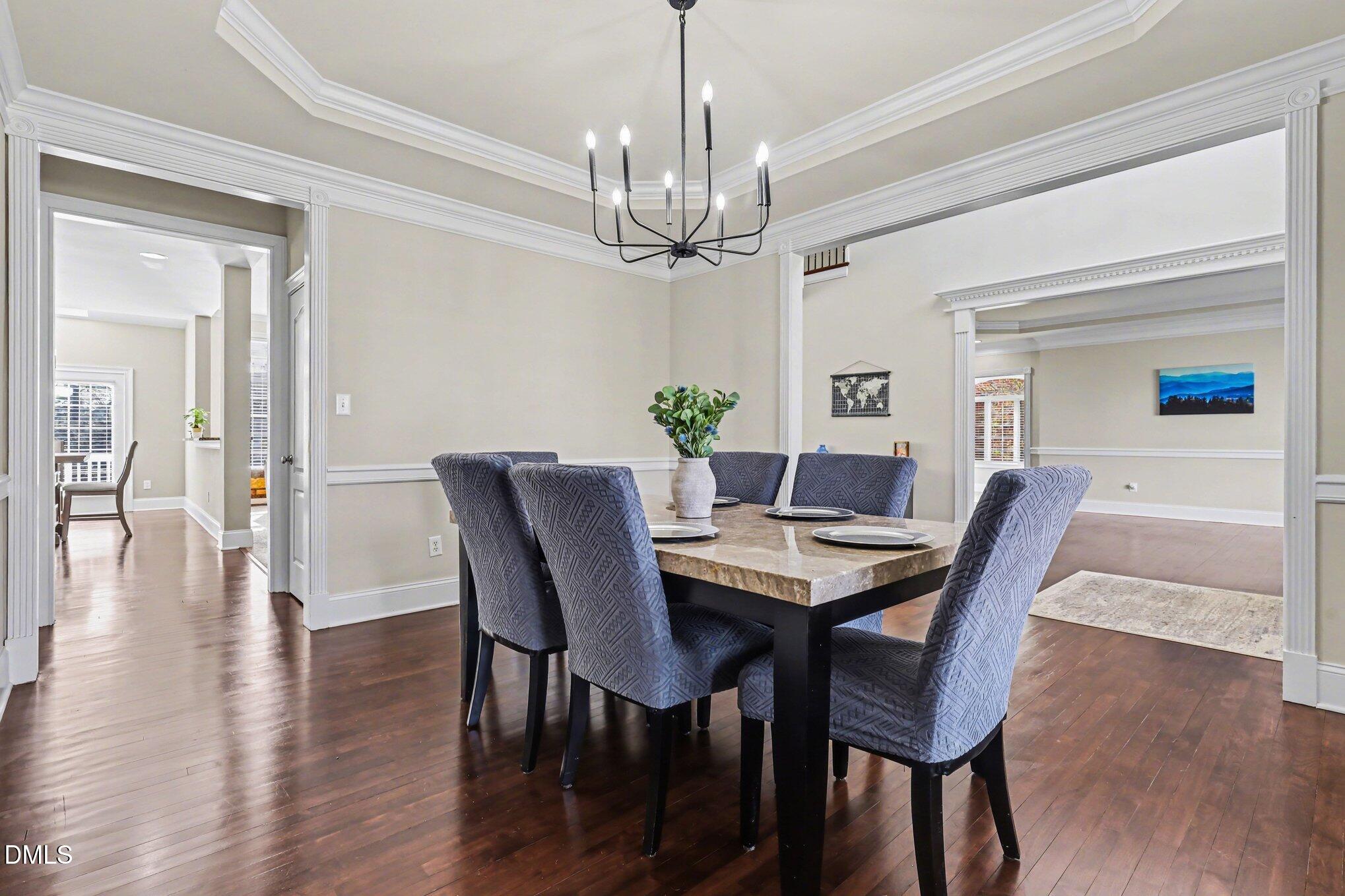 10643 Tarton Fields Circle Raleigh, NC 27617 - Photo 9 of 53 a view of a dining room with furniture a chandelier and wooden floor
