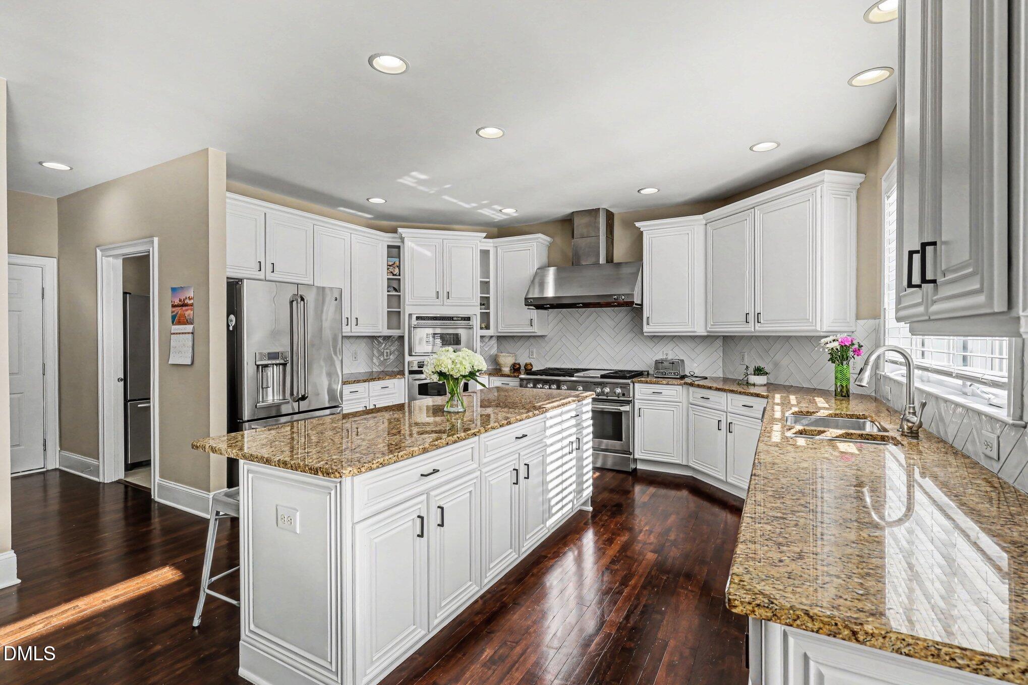 10643 Tarton Fields Circle Raleigh, NC 27617 - Photo 13 of 53 a kitchen with stainless steel appliances granite countertop a sink refrigerator and cabinets