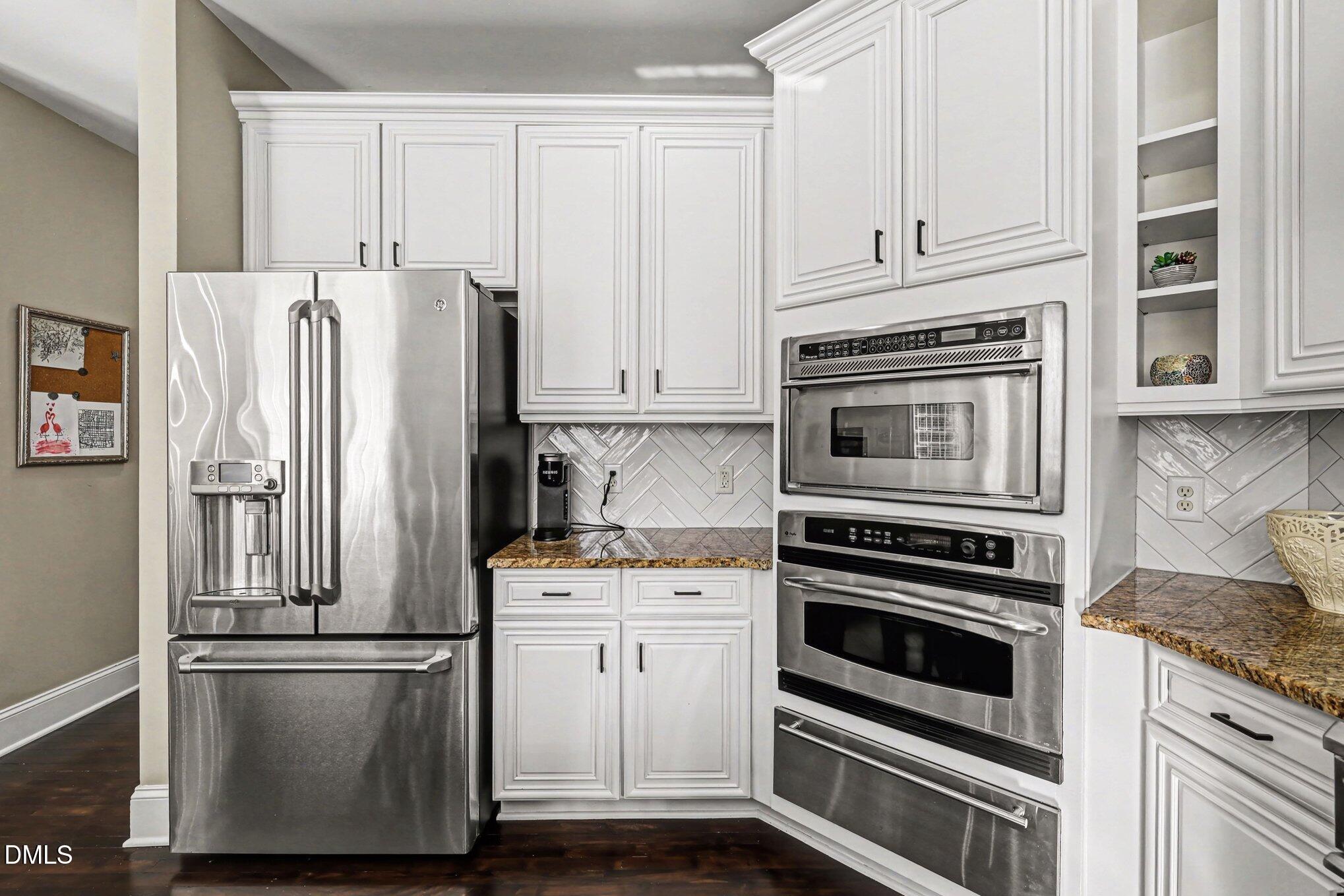 10643 Tarton Fields Circle Raleigh, NC 27617 - Photo 22 of 53 a kitchen with stainless steel appliances white cabinets and a refrigerator