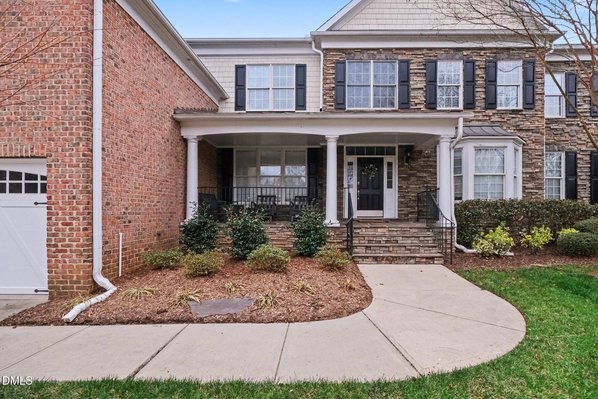 10643 Tarton Fields Circle Raleigh, NC 27617 - Photo 2 of 53 a view of a brick house with many windows plants and flower plants