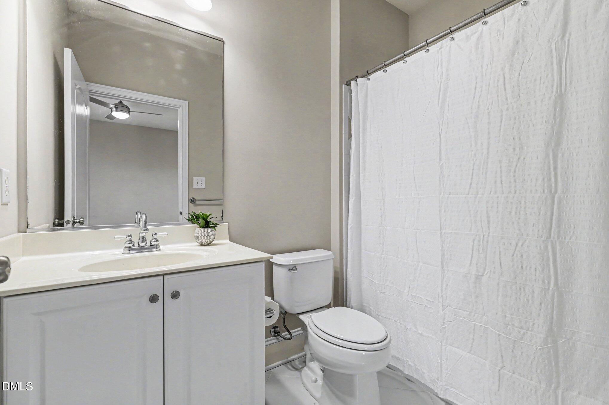 10643 Tarton Fields Circle Raleigh, NC 27617 - Photo 31 of 53 a bathroom with a sink a toilet and a mirror