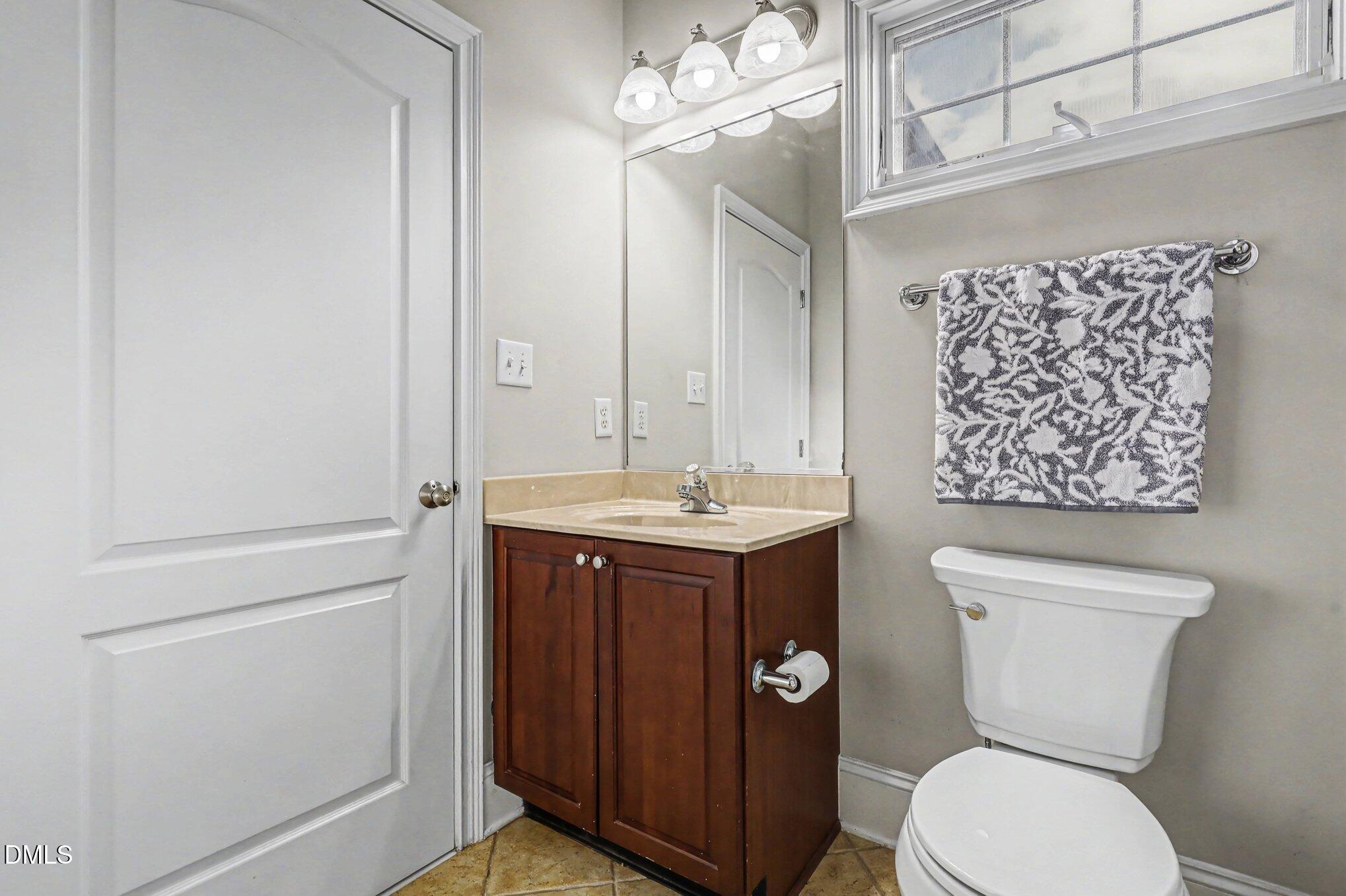 10643 Tarton Fields Circle Raleigh, NC 27617 - Photo 44 of 53 a bathroom with a toilet sink and mirror