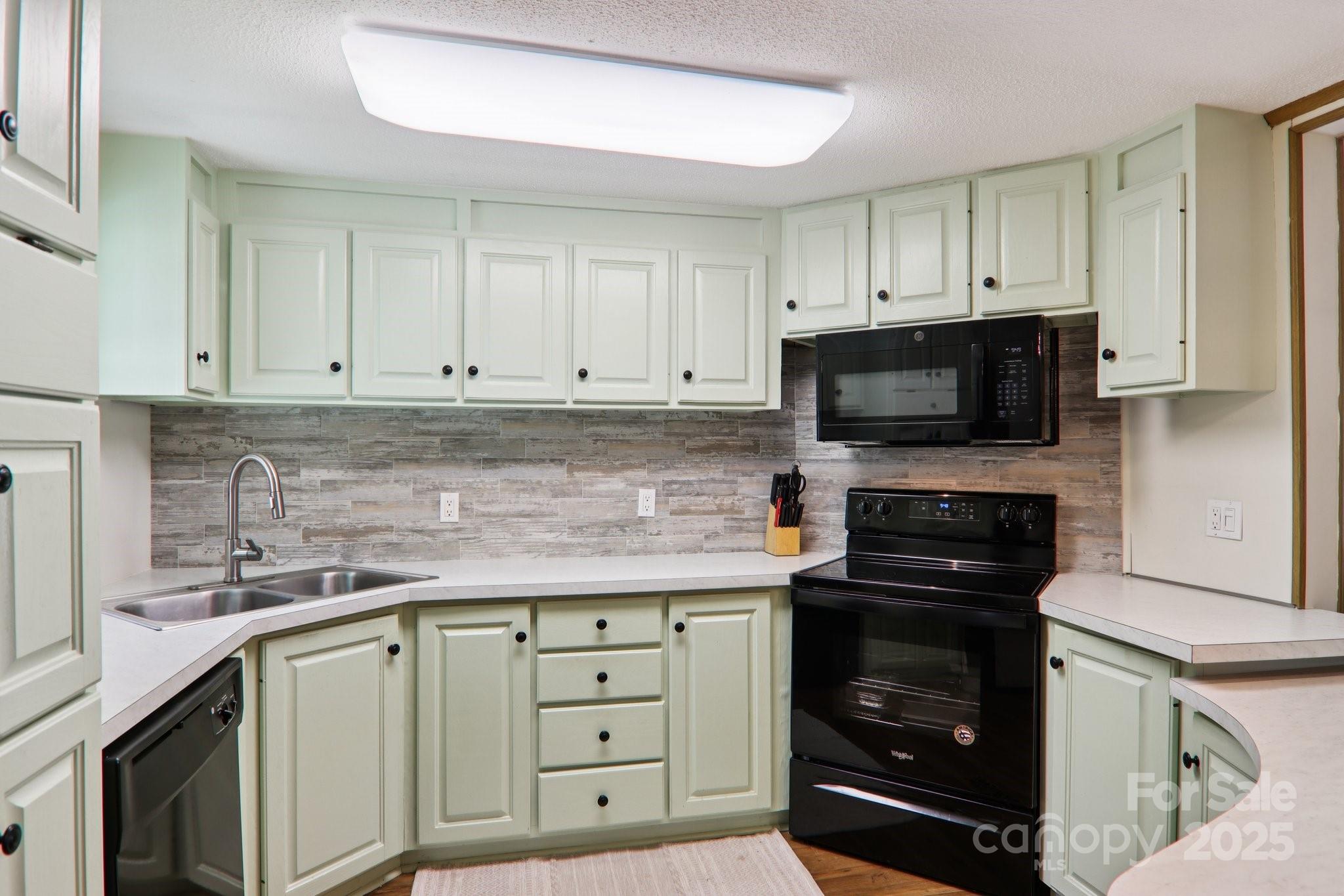226 Cranbrook Circle Hendersonville, NC 28792 - Photo 13 of 47 a kitchen with granite countertop white cabinets and stainless steel appliances