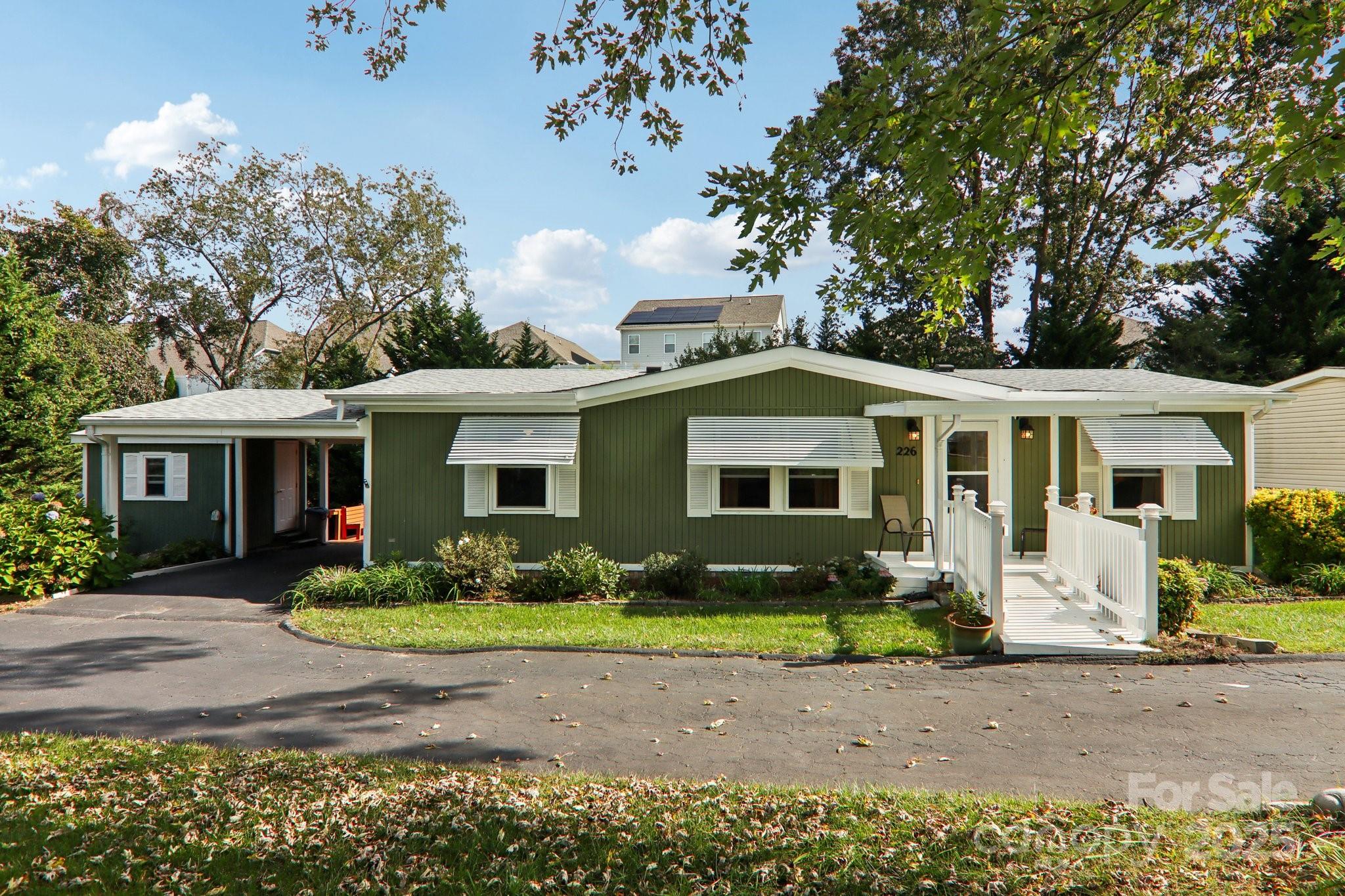 226 Cranbrook Circle Hendersonville, NC 28792 - Photo 2 of 47 a front view of a house with garden