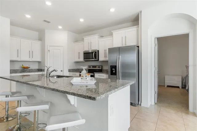 a kitchen with stainless steel appliances granite countertop a sink and a refrigerator