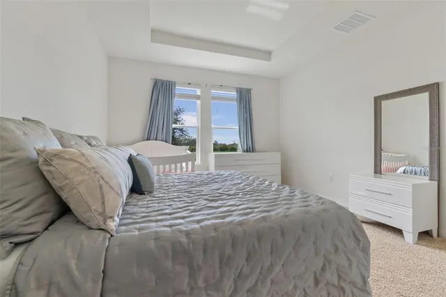 a bed sitting in a bedroom next to a bathroom