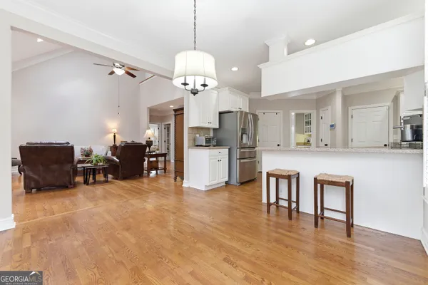 a kitchen with stainless steel appliances granite countertop a refrigerator sink and white cabinets