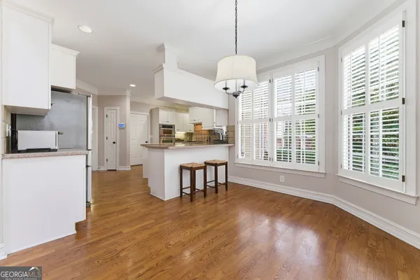 a kitchen with stainless steel appliances granite countertop a white cabinets and wooden floors