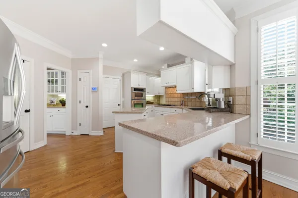 a kitchen with granite countertop a stove sink and cabinets