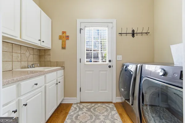 a spacious bathroom with a double vanity sink a two mirror a window and a bathtub