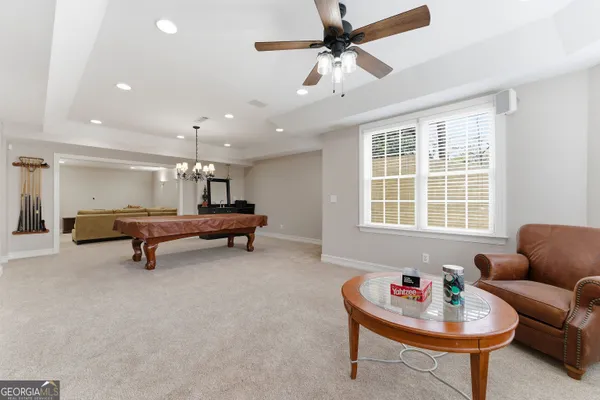 a view of an empty room with wooden floor and a ceiling fan