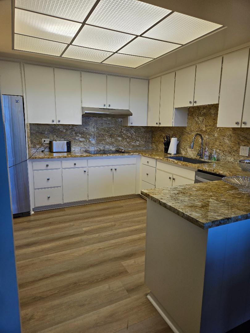 899 Island Drive, Unit 110 Rancho Mirage, CA 92270 - Photo 14 of 15 a kitchen with granite countertop white cabinets and white appliances