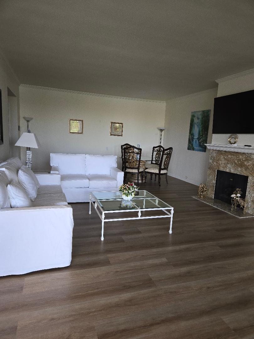 899 Island Drive, Unit 110 Rancho Mirage, CA 92270 - Photo 5 of 12 a living room with furniture a flat screen tv and a fireplace