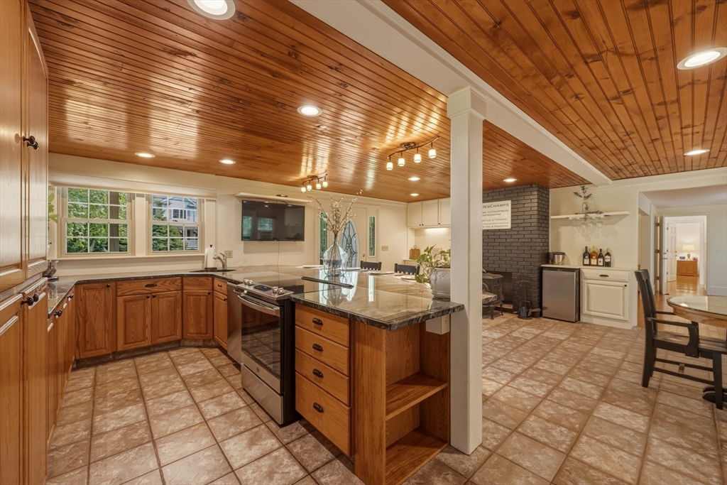 90 Rounsevell Road Tewksbury, MA 01876 - Photo 3 of 42 a kitchen with stainless steel appliances kitchen island granite countertop a stove a sink and a refrigerator