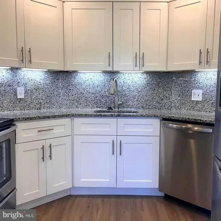 a kitchen with granite countertop cabinets and white appliances