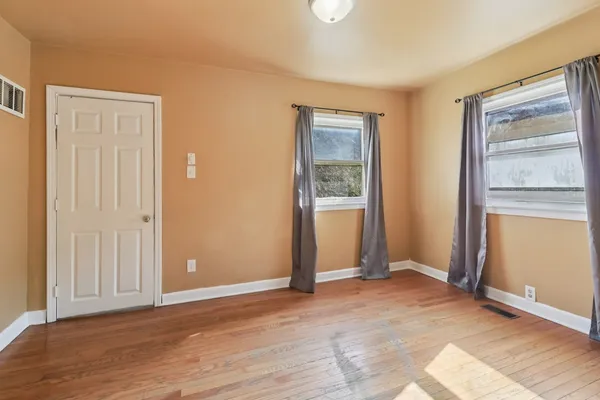 an empty room with windows and closet