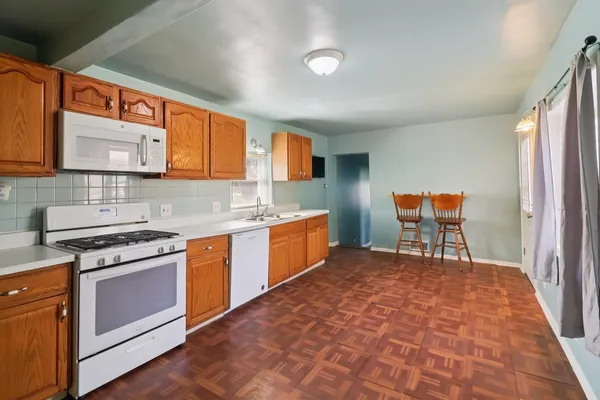 a kitchen with stainless steel appliances granite countertop a stove a sink and a microwave