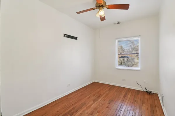 an empty room with a window and wooden floor