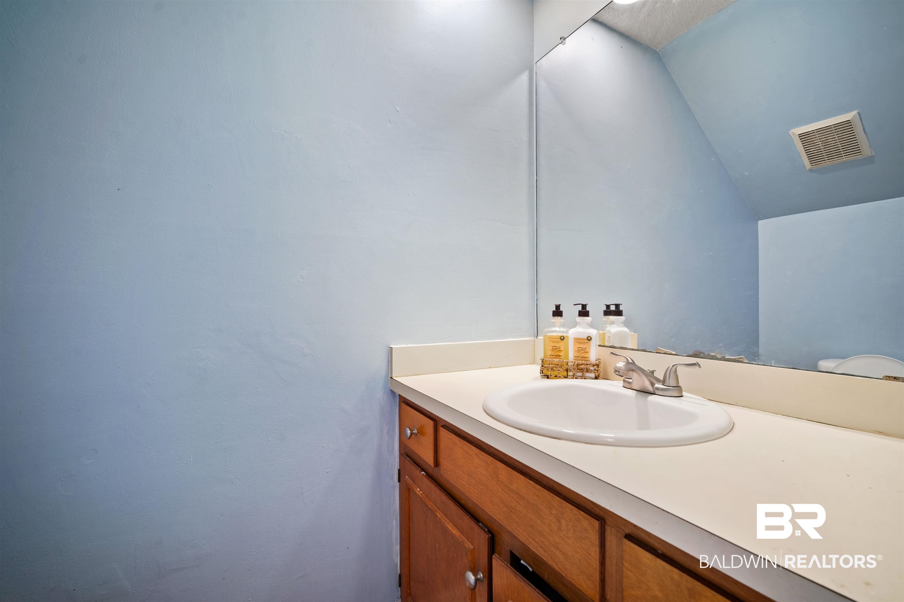 2823 Woodland Road Mobile, AL 36693 - Photo 22 of 29 Bathroom featuring vaulted ceiling, vanity, and visible vents