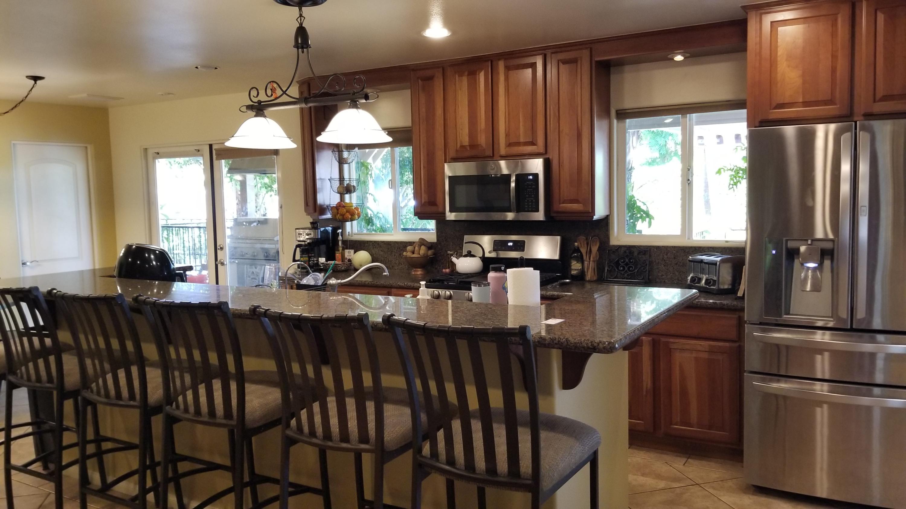 68446 Terrace Road Cathedral City, CA 92234 - Photo 2 of 81 a kitchen with stainless steel appliances granite countertop a stove a sink dishwasher a dining table and chairs with wooden floor