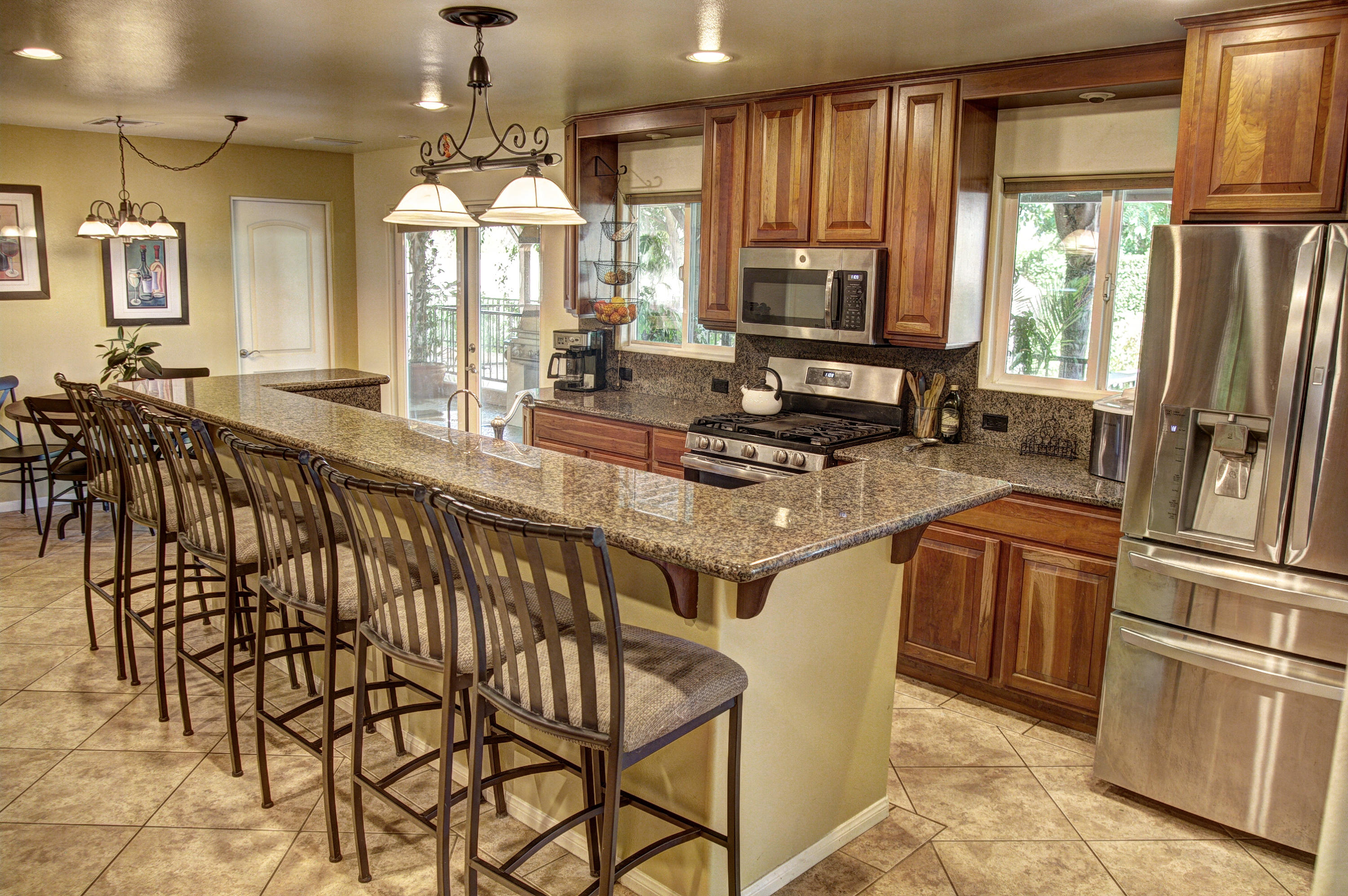 68446 Terrace Road Cathedral City, CA 92234 - Photo 20 of 81 a kitchen with stainless steel appliances granite countertop a refrigerator a sink dishwasher a stove and a dining table with wooden floor
