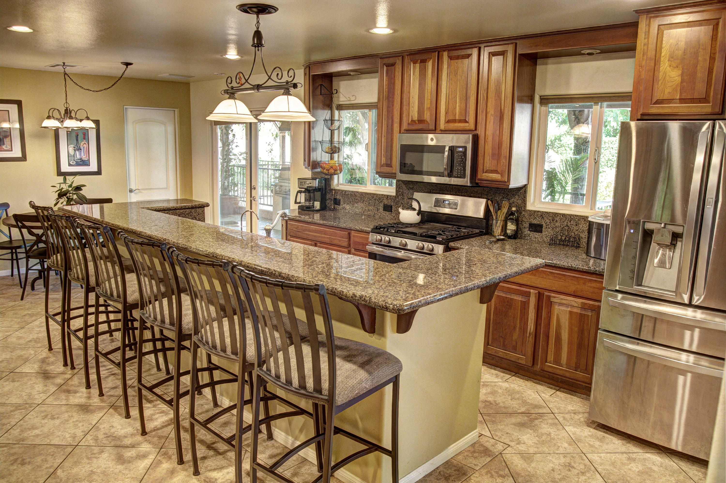 68446 Terrace Road Cathedral City, CA 92234 - Photo 21 of 81 a kitchen with stainless steel appliances granite countertop a refrigerator a sink dishwasher a stove and a dining table with wooden floor