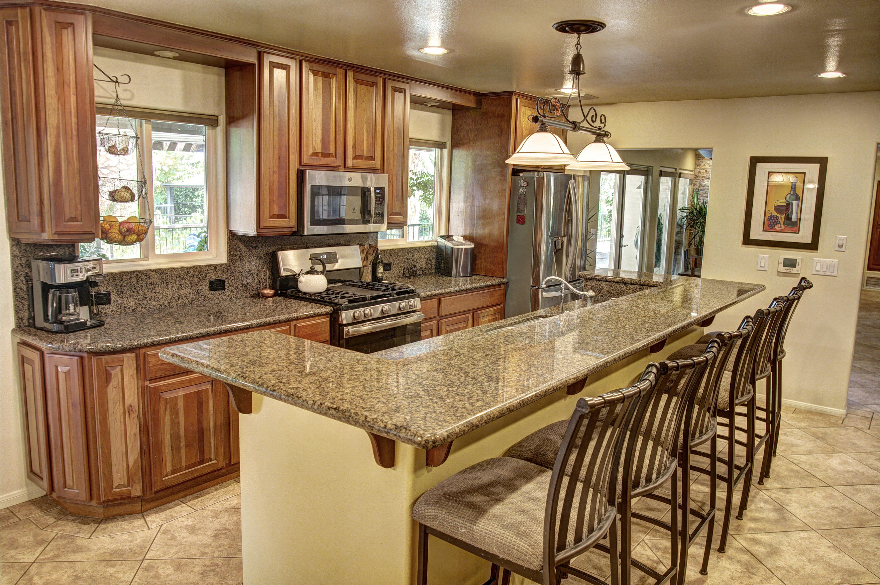 68446 Terrace Road Cathedral City, CA 92234 - Photo 25 of 81 a kitchen with stainless steel appliances granite countertop a stove a sink a microwave and dining table
