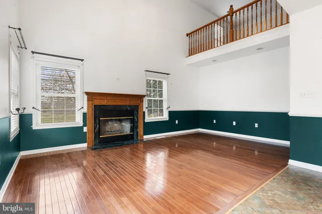 a view of an empty room with a window and fireplace