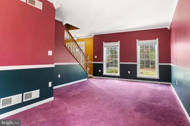 a view of an empty room with a fireplace and a window
