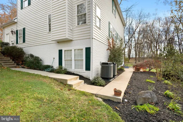 a view of a white house with a yard and large tree
