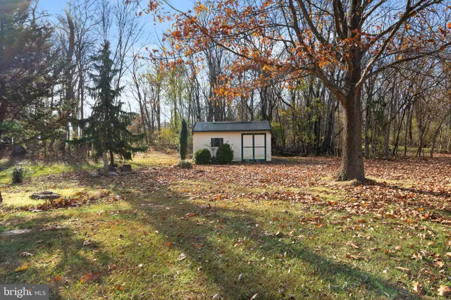 a front view of a house with a yard and large trees