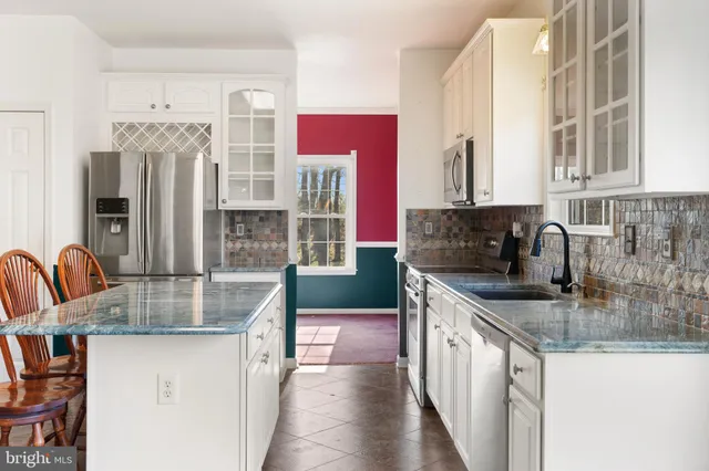 a kitchen with stainless steel appliances granite countertop a sink dishwasher and cabinets with wooden floor
