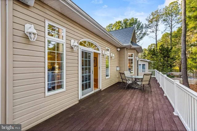 a view of a balcony with chairs and wooden floor