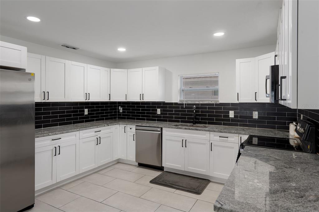 5106 Pacific Avenue Spring Hill, FL 34606 - Photo 9 of 23 a kitchen with granite countertop a sink and cabinets